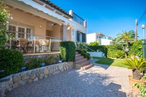 a house with a stone retaining wall and stairs at Villa Loli in Alcudia