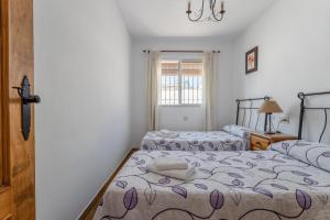 a bedroom with two beds and a window at Cortijo Encarni in Frigiliana +15 photos