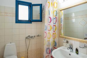 a bathroom with a sink and a toilet and a mirror at Studios Ninemia Serifos 3 in Livadi