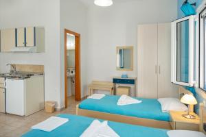 a small room with two beds and a kitchen at Studios Ninemia Serifos 3 in Livadi