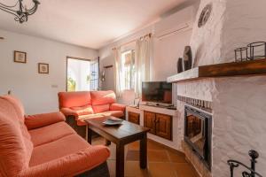 a living room with a fireplace and a tv at Cortijo Encarni in Frigiliana