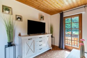 a living room with a television on a dresser at Ferienhaus Gießler in Nordrach
