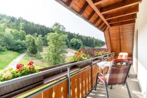 a balcony of a house with chairs and flowers at Ferienhaus Gießler in Nordrach