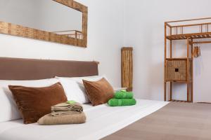 a white bed with a green stuffed animal on it at Boutique Beach Mataró in Mataró