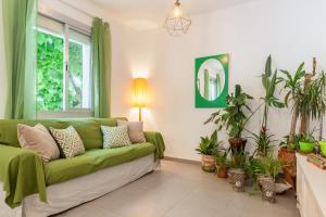 a living room with a green couch and potted plants at Boutique Beach Mataró in Mataró