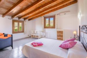 a bedroom with a large white bed with pink pillows at Villa Can Serra in Port de Pollensa