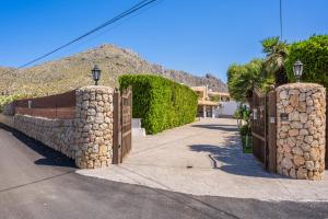 a gate to a house with a stone wall at Villa Can Serra in Port de Pollensa