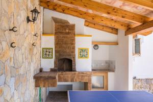 a kitchen with a stone wall with a pizza oven at Villa Can Serra in Port de Pollensa