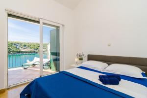 Un dormitorio con una cama azul y blanca y un balcón. en Apartments Regina Maris, en Klek