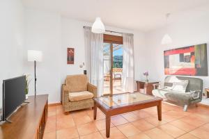 a living room with a tv and a couch and a table at Costa Luxe Almuñecar in Almuñécar