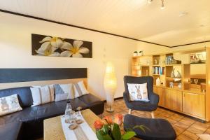 a living room with a couch and two chairs at Ferienwohnung Stork in Möhnesee