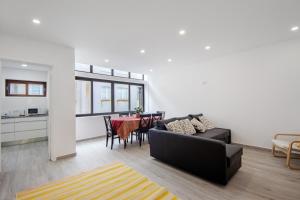 a living room with a couch and a table at T4 Furadouro with sea view in Ovar