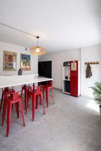 a dining room with a red table and red chairs at Therma Pilgrim Hostel in Caldas de Reis