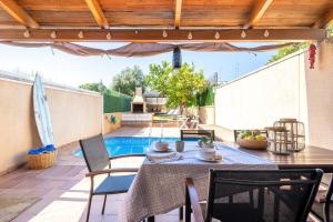 a patio with a table and chairs and a pool at another day in paradise in Calafell