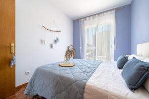 a bedroom with a bed with blue walls and a window at another day in paradise in Calafell +19 photos