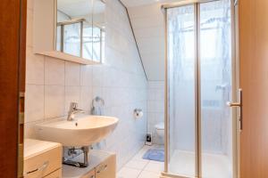 a bathroom with a sink and a shower at Ferienwohnung zum Seeblick in Öhningen +18 photos