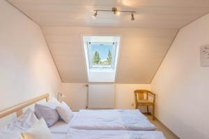a bedroom with a bed and a window at Ferienwohnung zum Seeblick in Öhningen