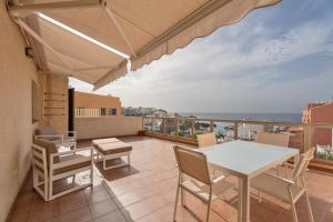 a patio with a table and chairs on a balcony at Ático Bellavista B - Alcalá in Guía de Isora