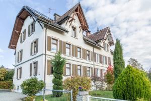 a large white building with a brown roof at Ferienwohnung zum Seeblick in Öhningen