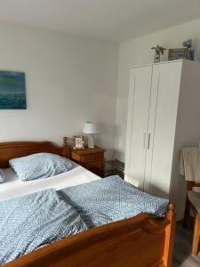 a bedroom with a bed and a white cabinet at Ferienhuus Tüütje in Wolthusen