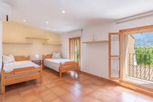 a bedroom with two beds and a window at Cas Pobres in Sóller