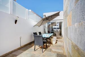 a patio with a table and chairs and an umbrella at Preciosa Casa En Lanzarote in Tahiche