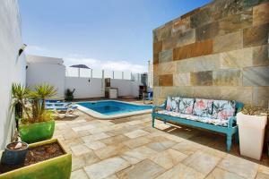 a patio with a couch and a swimming pool at Preciosa Casa En Lanzarote in Tahiche
