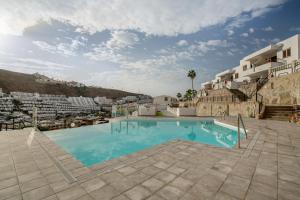 a large swimming pool in a resort with buildings at Sun and serenity pool wifi in Puerto Rico de Gran Canaria