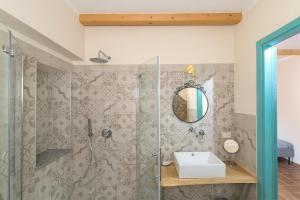 a bathroom with a shower with a sink and a mirror at Al posto giusto -appartamento Gioia in Riotorto +23 photos