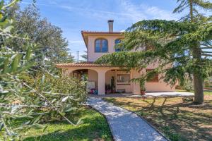 a house with a pathway leading to the front of it at Al posto giusto -appartamento Gioia in Riotorto