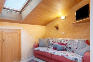 a living room with a red couch and a skylight at Stampferhof in Völs am Schlern