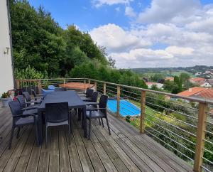 a deck with tables and chairs and a swimming pool at Villa des ermites in Favières