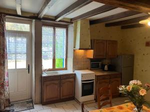 a kitchen with a white stove top oven next to a window at Chez Manon in Massangis