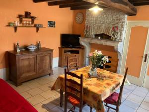 a dining room with a table and a fireplace at Chez Manon in Massangis