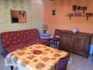 a living room with a couch and a table at Chez Manon in Massangis +3 photos