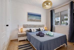 a bedroom with a blue bed with pillows on it at Casa Verdemar in Corralejo +17 photos