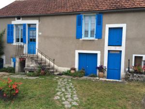 a house with blue doors and flowers in a yard at Chez Manon in Massangis