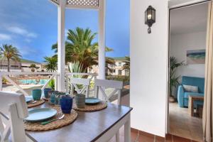 a dining table on the balcony with a view of the beach at Casa Verdemar in Corralejo