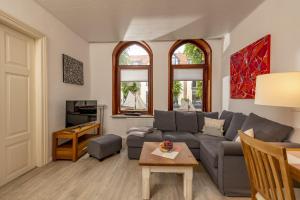 a living room with a couch and a table at Ferienwohnungen Wiese - Nickel 2 in Arnis +8 photos