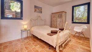 a bedroom with a bed and a chair in it at Costacabana - Casa Adora in Tossa de Mar
