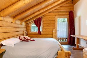 a bedroom with a bed in a log cabin at Agritur Cazzuffi in Peio