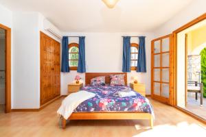 a bedroom with a bed and blue curtains at Villa Rosa in Calonge +21 photos