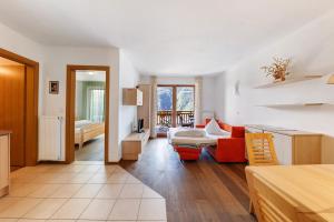a living room with a red couch and a table at Obertrisaierhof Wohnung 2 in Fie allo Sciliar