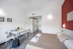 a bedroom with a bed and a table and a dining room at Appartamento Monolocale Rebi in Imperia +18 photos