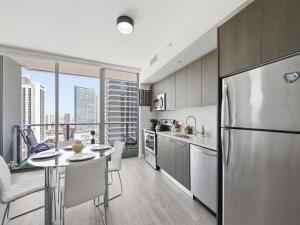 a kitchen with a stainless steel refrigerator and a table at Brickell Bay View in Miami