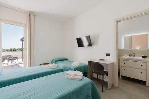 a bedroom with two beds and a desk and a mirror at Bed And Breakfast Champagneria in Castelvetrano Selinunte
