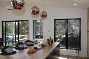 a kitchen with large windows and a table with food on it at Chalet Le Select - Private Spa with River View in Les Éboulements