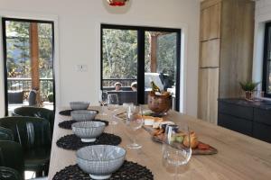 a wooden table with wine glasses and food on it at Chalet Le Select - Private Spa with River View in Les Éboulements +21 photos