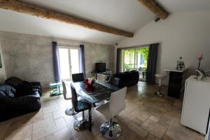 a living room with a table and a couch at Maison L'oustalette De Mau-bé in Maubec