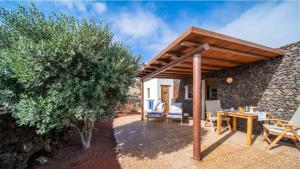 a patio with a wooden pergola and a table and chairs at Casa Margarita 3 in Mala +2 photos
